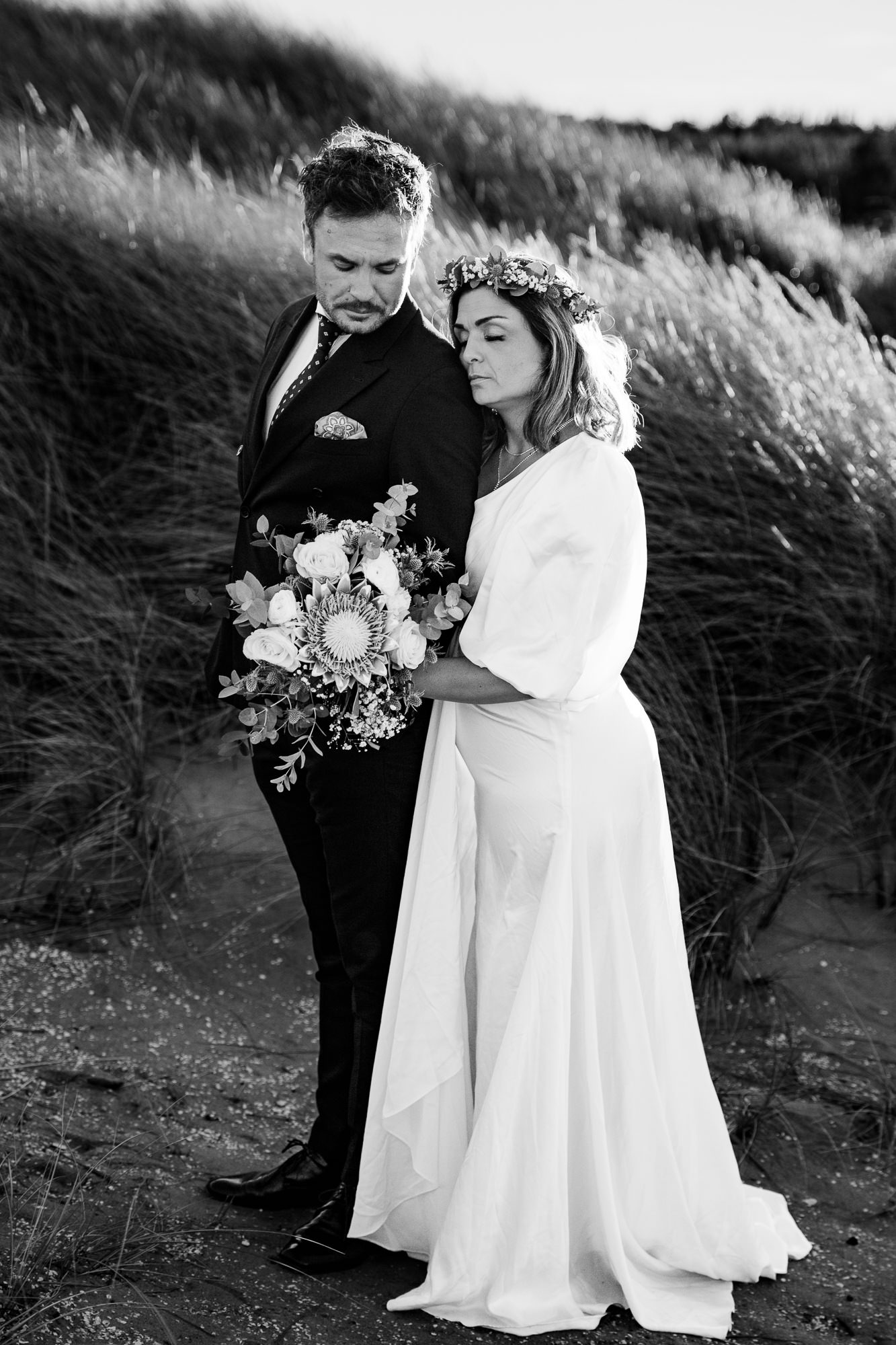 brud med bröllopsbukett tillsammans med sin blivande man i ett fotografering på stranden. Bröllopfotograf i Skåne_ av Fotoepok